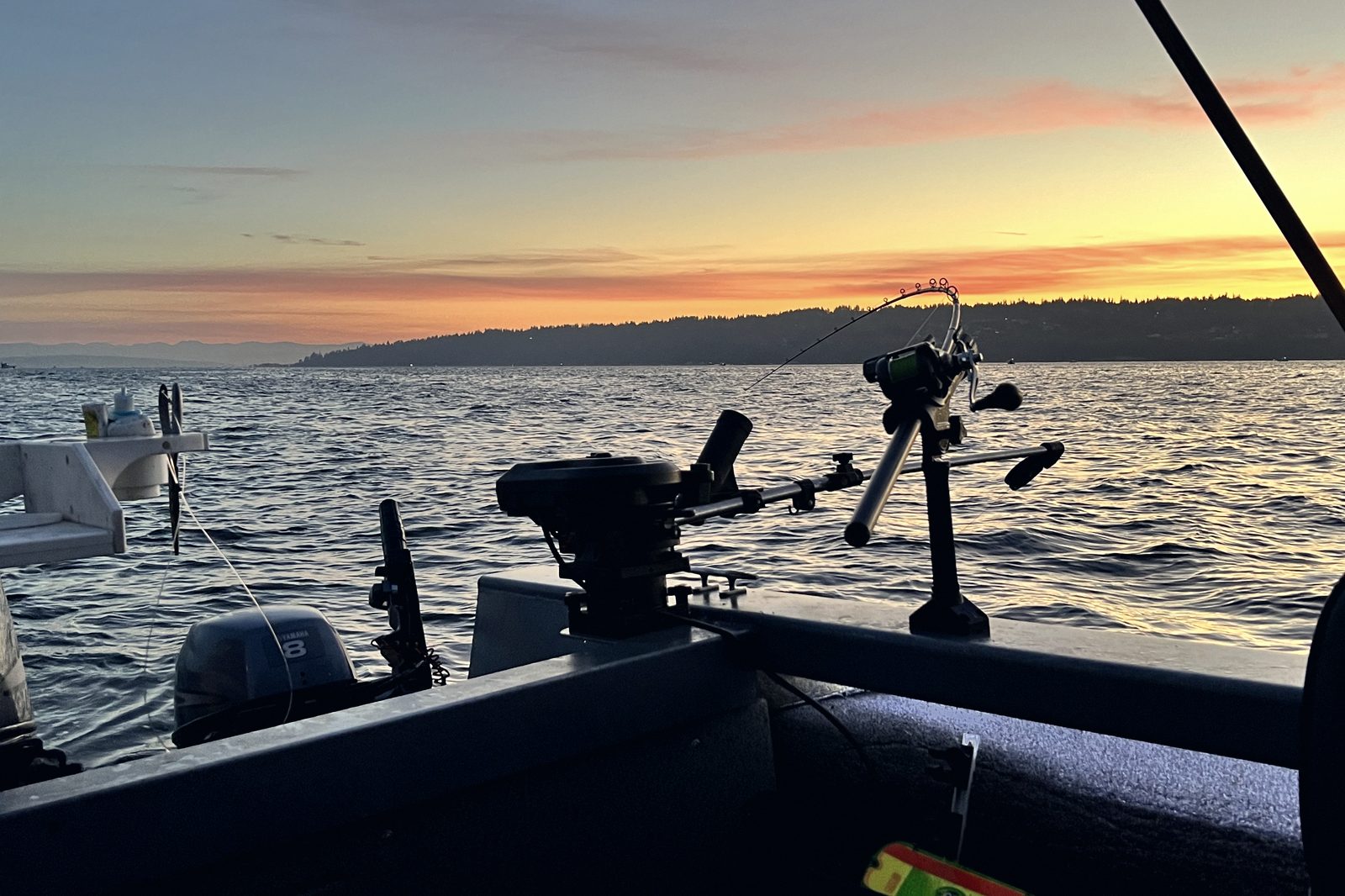 A rod loaded in its holder at dawn with the shoreline behind.